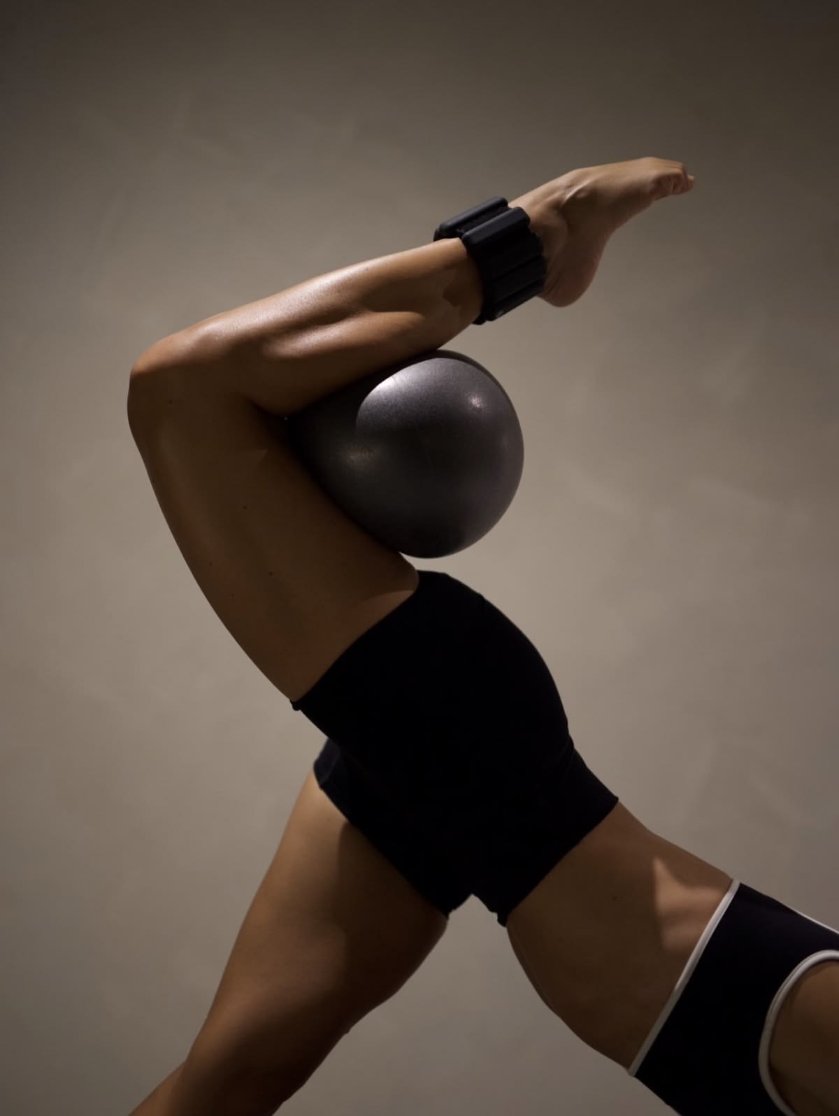 Alumna de Mova Studio en ejercicio de control con balón pilates, técnica de Barre